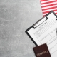 American flag, visa application form, passport and glasses on light grey table, flat lay. Space for text