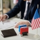 Close up of approved and rejected stamps on table in US immigration office with flag, copy space
