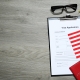 Visa application form, American flag, passports and stationery on wooden table, flat lay. Space for text