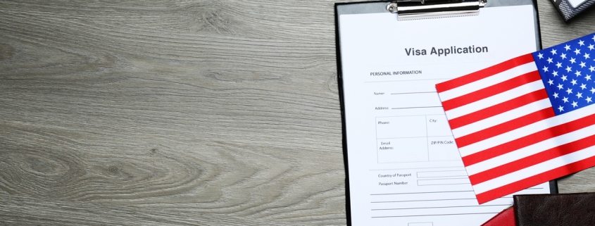 Visa application form, American flag, passports and stationery on wooden table, flat lay. Space for text