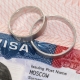 Newlyweds rings on a US visa close-up as an idea of marriage relocation.